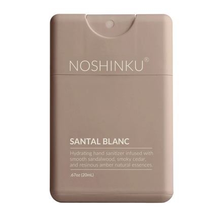 Noshinku Santal Blanc hand sanitizer dispenser in a matte taupe-brown color, featuring white text and a flip-top cap, set against a plain white background.